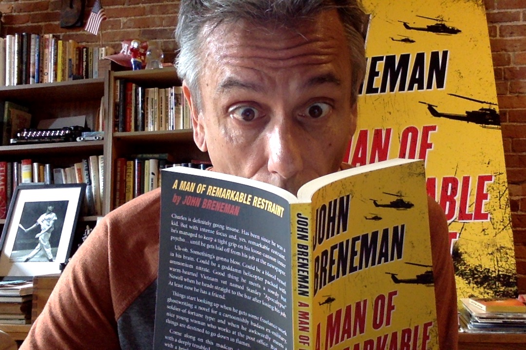 John Breneman holding his debut novel, "A Man of Remarkable Restraint"