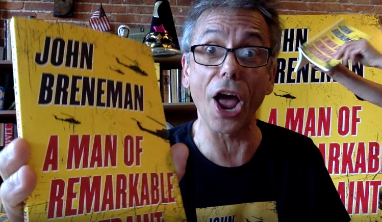 John Breneman holding his debut novel, "A Man of Remarkable Restraint"
